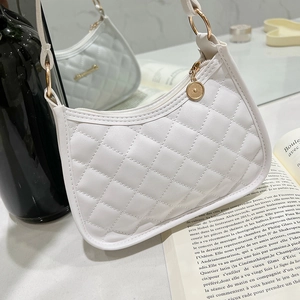 Elegant white quilted crossbody bag with diamond stitch detail in a lifestyle setting