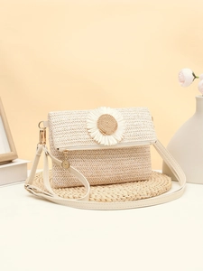 Detailed view of woven straw bag featuring a decorative white daisy and metal zip fastener