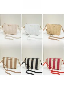 Detail view of woven straw bags with striped textures, metal zippers and logo clasps