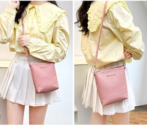 Detailed pink bucket bag with V-shaped woven texture and gold metallic logo
