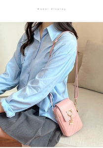 Detailed view of pink crossbody bag with cat ear ring and pearl tassel on a model