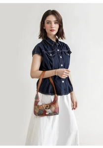 Detailansicht der Vintage-Patchwork-Tasche mit goldenem Katzenanhänger und Perlenquaste