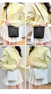Detail showing woven texture and gold logo on black and white bucket bags