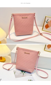 Detail of pink woven bucket bag with V-shaped texture and gold metal logo plaque