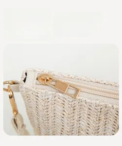 Detail of premium golden metal zipper and fine woven texture on white straw bag