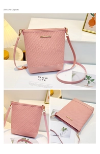 Detail of pink bucket bag featuring woven texture, gold metal logo and adjustable strap