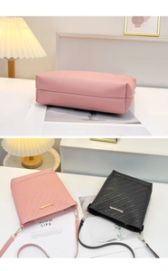 Detail of embossed leather crossbody bags in pink and black with gold metal hardware