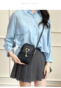 Detailed view of women's mini crossbody bag with golden cat-ear clasp and pearl tassel