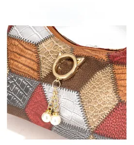 Details von Vintage-Patchwork-Tote mit buntem Kunstleder und goldenem Katzenring-Anhänger