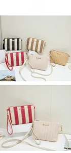 Detail of woven straw clutch bags with metal zippers and various stripe patterns