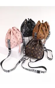 Macro shot of stylish drawstring bucket bags in four colors with logo wide straps
