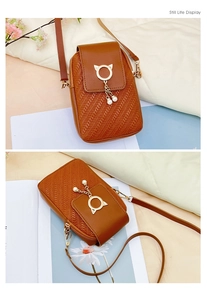 Detail of brown PU crossbody bag featuring golden cat-ear metal ring and pearl tassel