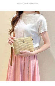 Pochette enveloppe en paille avec boucle florale en métal et dragonne en cuir souple