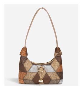 Detail der Vintage-Tote-Tasche mit Tiermuster-Patchwork und goldenem Katzen-Anhänger