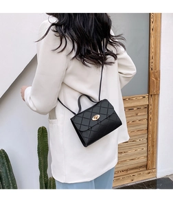 Quilted black PU leather shoulder bag with gold twist lock shown on a model