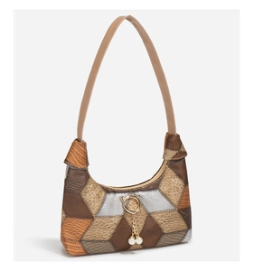 Detail der Patchwork-Tasche aus Kunstleder mit Krokostruktur und Gold-Katzenanhänger