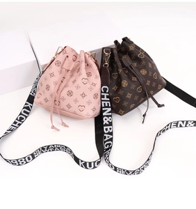 Detailed close-up of monogram bucket bags with drawstring closure and wide canvas straps
