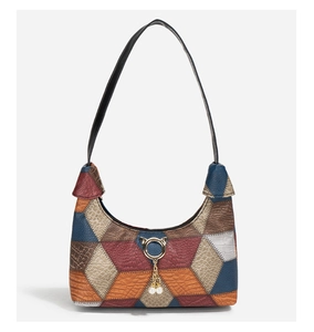 Detailansicht der Boho-Patchwork-Ledertasche mit goldenem Katzenanhänger und Perlen