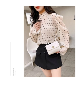 Elegant white quilted crossbody bag styled with a beige polka dot blouse and black skirt