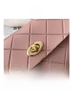 Detail of pink quilted handbag showing gold metal twist lock and luxury PU leather texture