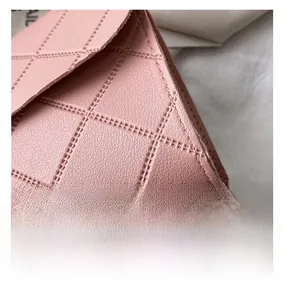 Detailed close-up of pink quilted faux leather material with fine texture and stitching