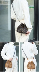 Detail of drawstring bucket bag featuring heart print and stylish lettered wide strap
