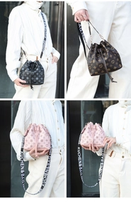 Detail of drawstring bucket bags with floral patterns and lettered wide straps