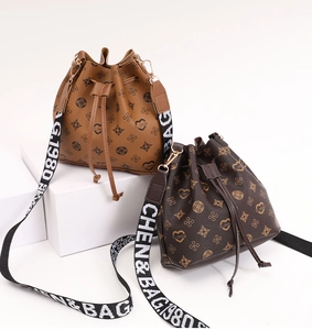 Detail of drawstring bucket bags with heart pattern and wide branded shoulder strap