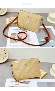 Détail du sac en paille tressée avec logo trèfle et bandoulière en cuir marron