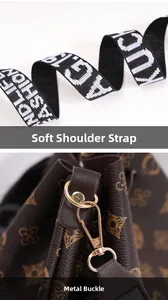 Close-up of the wide fabric strap and golden metal hardware of a brown bucket bag