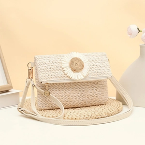 Beige woven straw crossbody bag with daisy floral accent and gold hardware detail