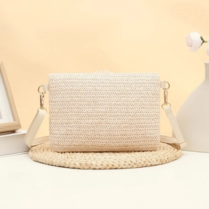 Woven straw crossbody bag with white leather strap and daisy accents for summer vacations