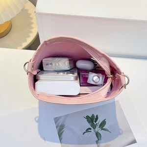 Pink embossed bucket bag interior showing spacious capacity for phone and essentials