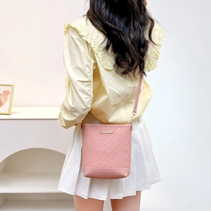 Pink embossed bucket bag with gold logo and shoulder strap for casual styling