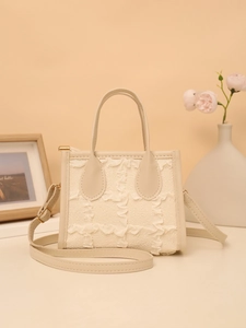 Detail of elegant beige handbag featuring textured ruffle grid and gold hardware