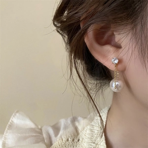 Detailed close-up of long tassel earrings featuring pearls and sparkling rhinestones