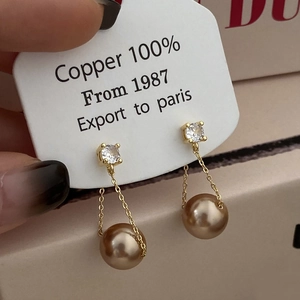 Close-up of elegant long tassel earrings featuring champagne pearls and crystals