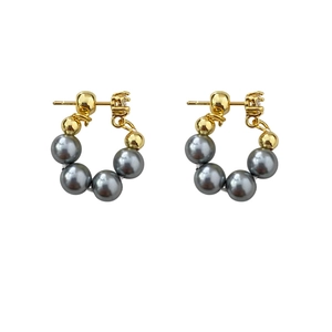 Elegant gold hoop earrings featuring gray pearls and metallic beads in a minimalist style