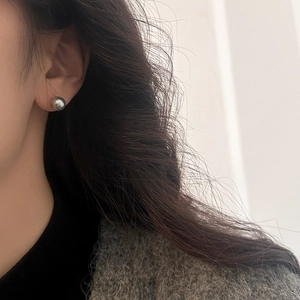 Close-up of elegant 10mm grey pearl stud earring on model showing metallic luster