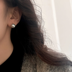 Close-up of a high-luster 10mm grey pearl stud earring worn on a model earlobe