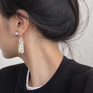 Silver metal leaf tassel earrings shown on model for a minimalist luxury fashion look