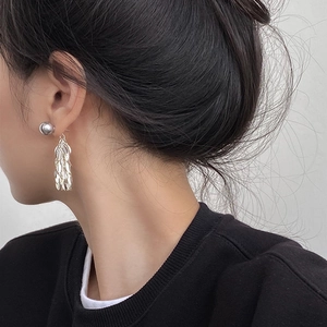 Macro shot of silver leaf tassel earrings showing metallic texture and hanging fringe