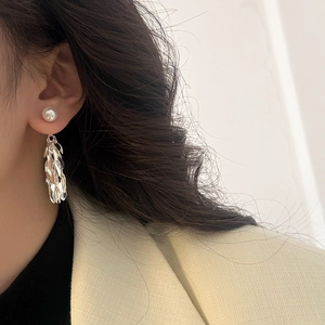Detail of silver leaf tassel earrings with white pearl and layered metal fringe