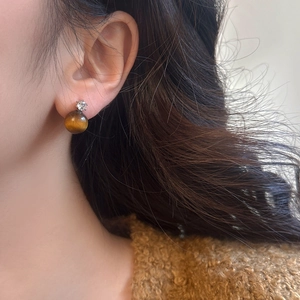 Elegant tiger eye stone stud earrings with zircon inlay worn by a female model