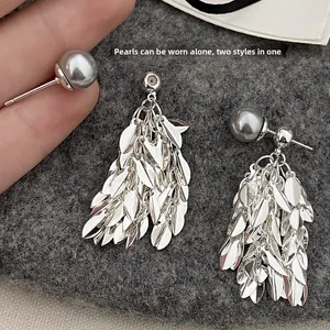 Detail of 2-in-1 earring showing grey pearl stud and detachable silver leaf tassels