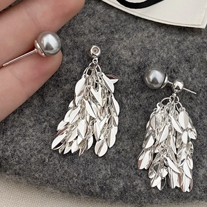 Detail of silver leaf tassel earrings with a grey pearl accent and metallic shine