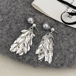 Detail of silver leaf fringe earrings with grey faux pearl studs on dark grey fabric