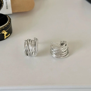 Vue de dessus de boucles d'oreilles en C argentées avec un design à anneaux multiples