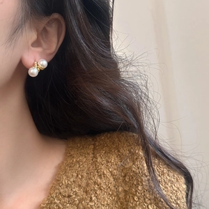 French vintage gold twist metal pearl earrings worn by a model with elegant style