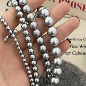 Comparaison de colliers en perles grises au lustre métallique sur tissu doux